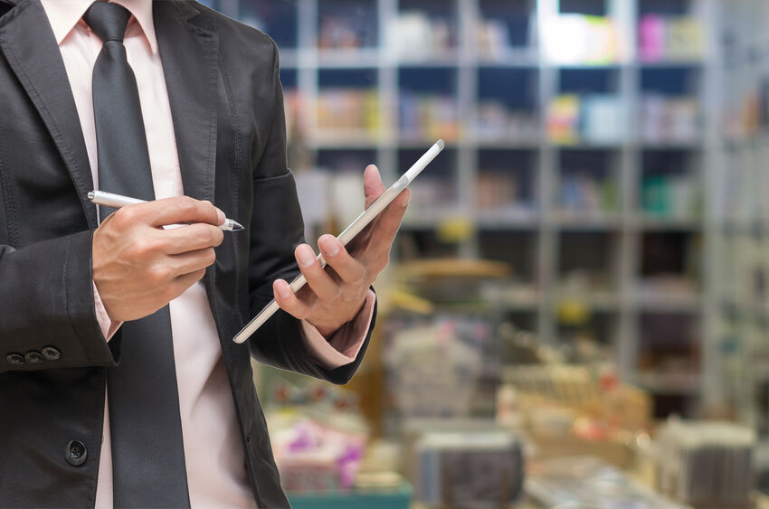 Businessman looking at a waste audit checklist at commercial facility