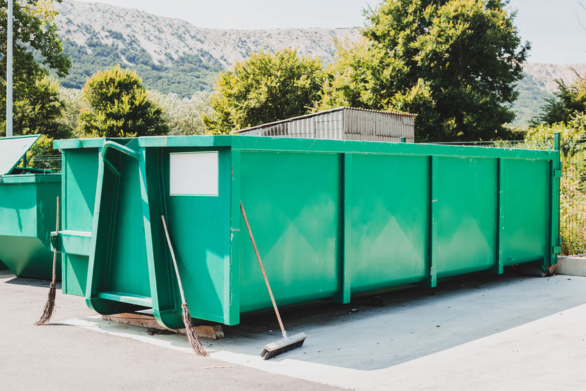 Large green garbage container at local waste sorting station.