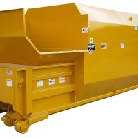 Yellow industrial waste compactor with a large hopper and safety labels, designed for compressing waste materials.