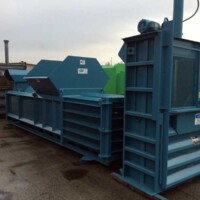 Blue industrial baler on a commercial worksite