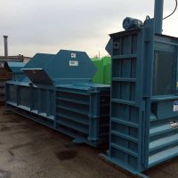 Blue industrial baler on a commercial worksite