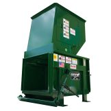 A green industrial metal baler machine with warning labels and a lever on the side.